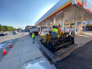 Commercial asphalt paving crew working at gas station parking lot