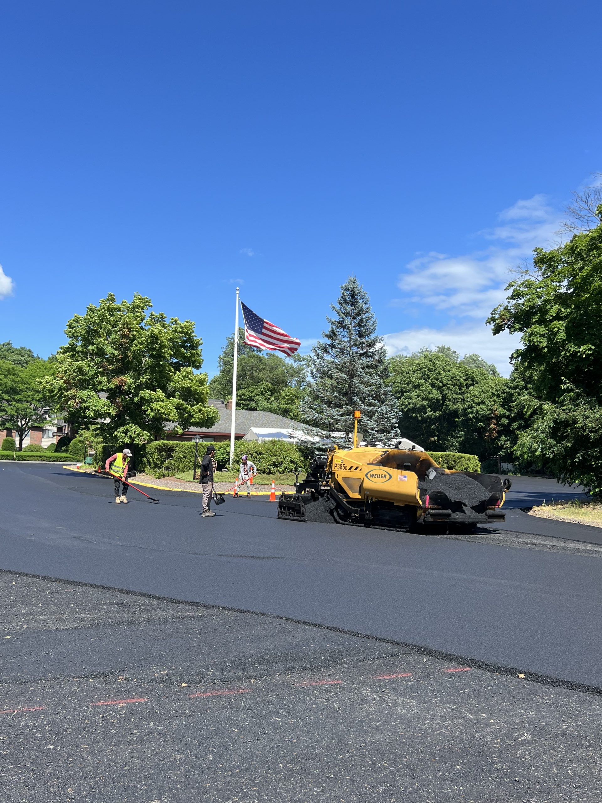 Asphalt paving crew resurfacing roadway in Norwood, MA.
