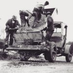 Vintage paving crew loading asphalt materials into work truck