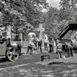 Historic road paving crew working with early asphalt equipment